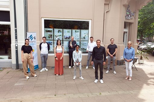 Architektur-Studierende der Hochschule RheinMain vor ihren Entwürfen für den Herderplatz in Wiesbaden mit Sabine Gaedeke (SEG) (1.v.r.), SEG-Geschäftsführer Roland Stöcklin (4.v.r.) und Prof. Sascha Luippold (3.v.r.). © Hochschulkommunikaton | Hochschule RheinMain.