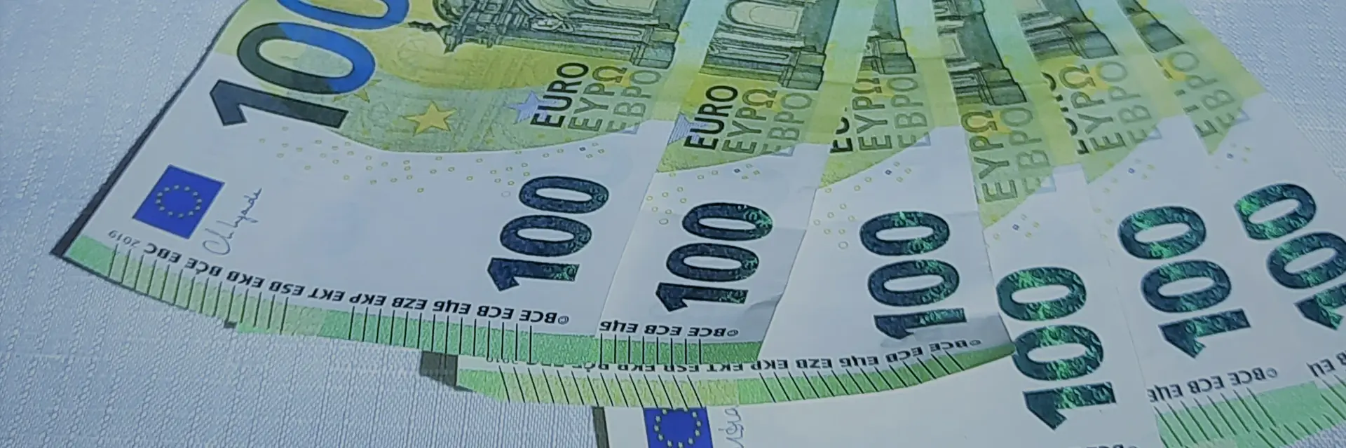 Hundert-Euro-Scheine liegen auf einem weissen Untergrund.