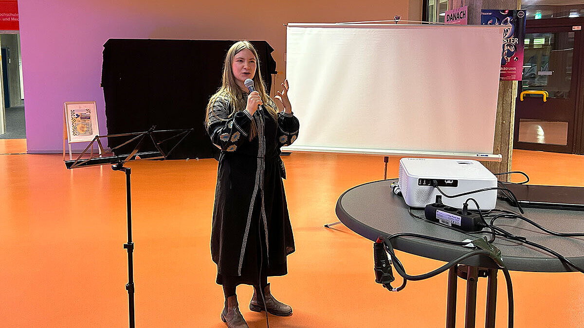 Daryna Blyshchuk, DAAD-Preisträgerin 2024, mit einem Mikrofon in der Hand.