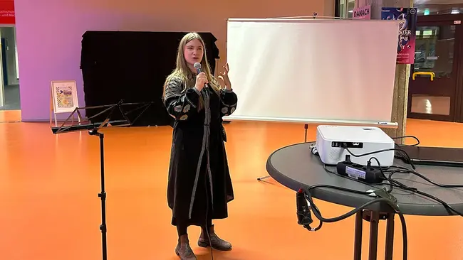 Daryna Blyshchuk, DAAD-Preisträgerin 2024, mit einem Mikrofon in der Hand.