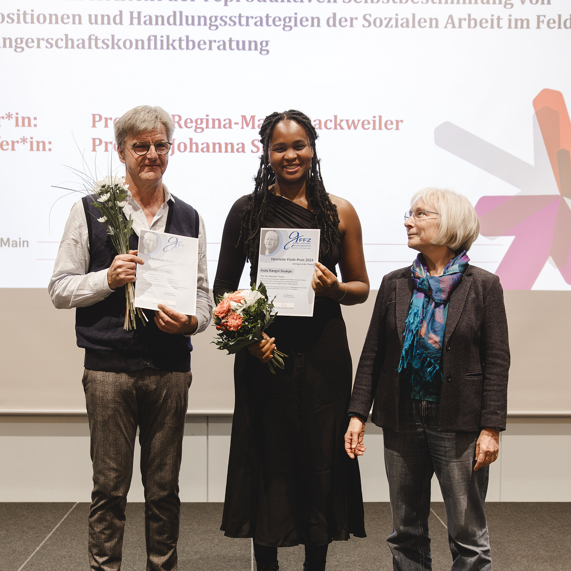 Die Preisträgerin Inola Kangni Soukpe erhält den Henriette-Fürth-Preis, neben ihr stehen ihr Betreuer Prof. Dr. Michael May und Prof. Dr. Lotte Rose