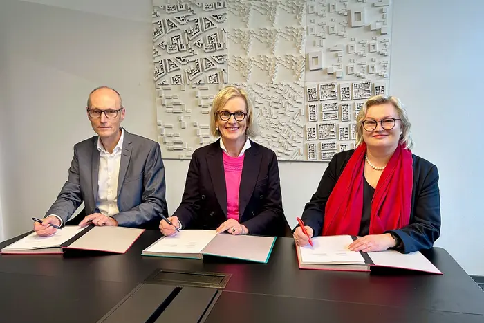 Prof. Dr. Friedmar Voormann, Kirsten Worms und Prof. Dr. Eva Waller unterzeichnen die gemeinsame Vereinbarung.