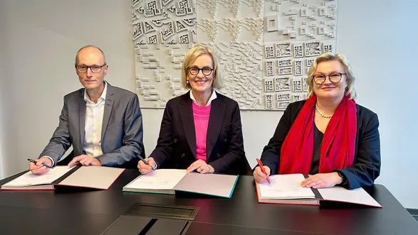Prof. Dr. Friedmar Voormann, Kirsten Worms und Prof. Dr. Eva Waller unterzeichnen die gemeinsame Vereinbarung.