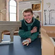 Stefan Simon mit seinem Entwurf zum Titel Lehm, Steine, Schindeln. 