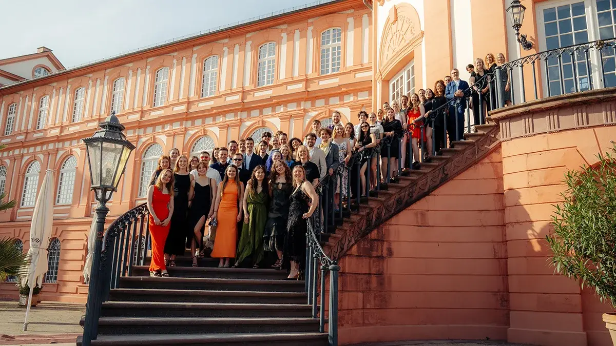 Die Absolvent:innen stehen auf einer Treppe des Schlosses Biebrich