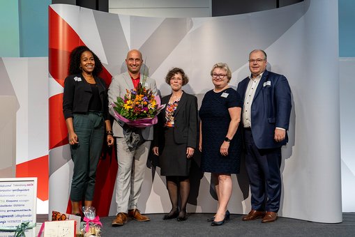 Gruppenfoto des Hochschulpräsidiums auf der Bühne, ganz links steht Thalia Moore, Referentin von Kanzler Dr. Martin Lommel