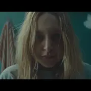 Eine junge Frau blickt direkt in die Kamera. Ihr Gesicht, das sie gerade gewaschen hat, ist nass.