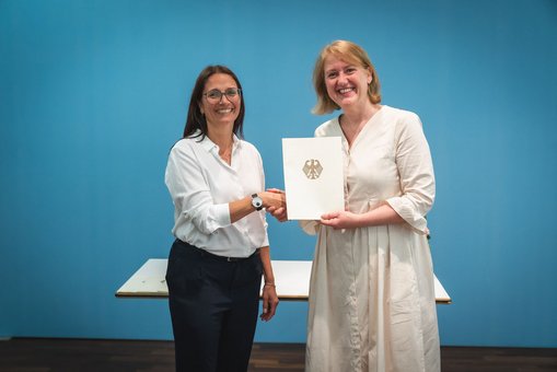 Prof. Dr. Davina Höblich (li.) erhält die Ernennungsurkunde von Bundesjugendministerin Lisa Paus.