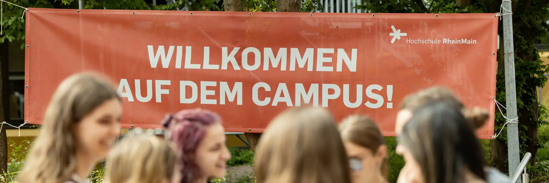 Studierende vor einem Willkommens-Banner