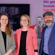 Drei Leute stehen vorne