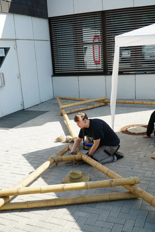eine Studentin baut eine Dachkonstruktion