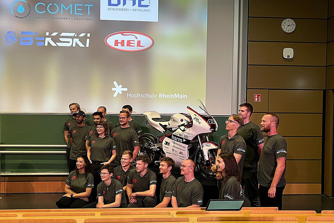 Das Team von RheinVolt Motorsport steht um das selbstgebaute Rennmotorrad herum