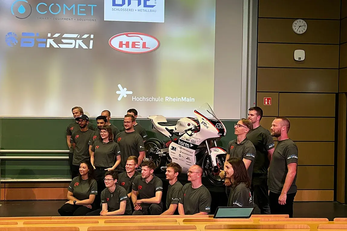 Das Team von RheinVolt Motorsport steht um das selbstgebaute Rennmotorrad herum