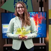 Maike Kaiser hält die Siegerinnen-Trophäe des ARD/ZDF Förderpreises „Frauen + Medientechnologie“ in den Händen.