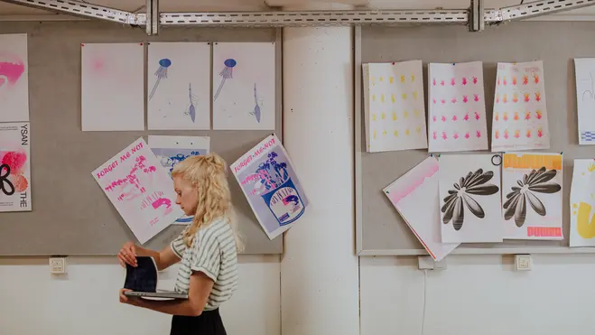 Studierende vor Druckprodukten in der Druckwerkstatt des Studiengangs Kommunikationsdesign