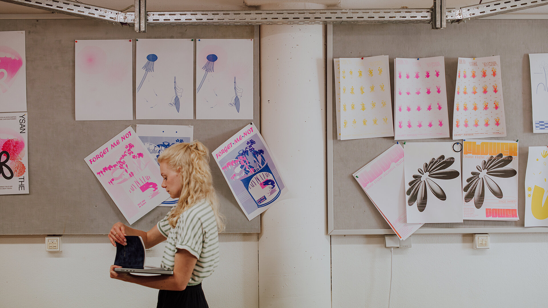 Studierende vor Druckprodukten in der Druckwerkstatt des Studiengangs Kommunikationsdesign