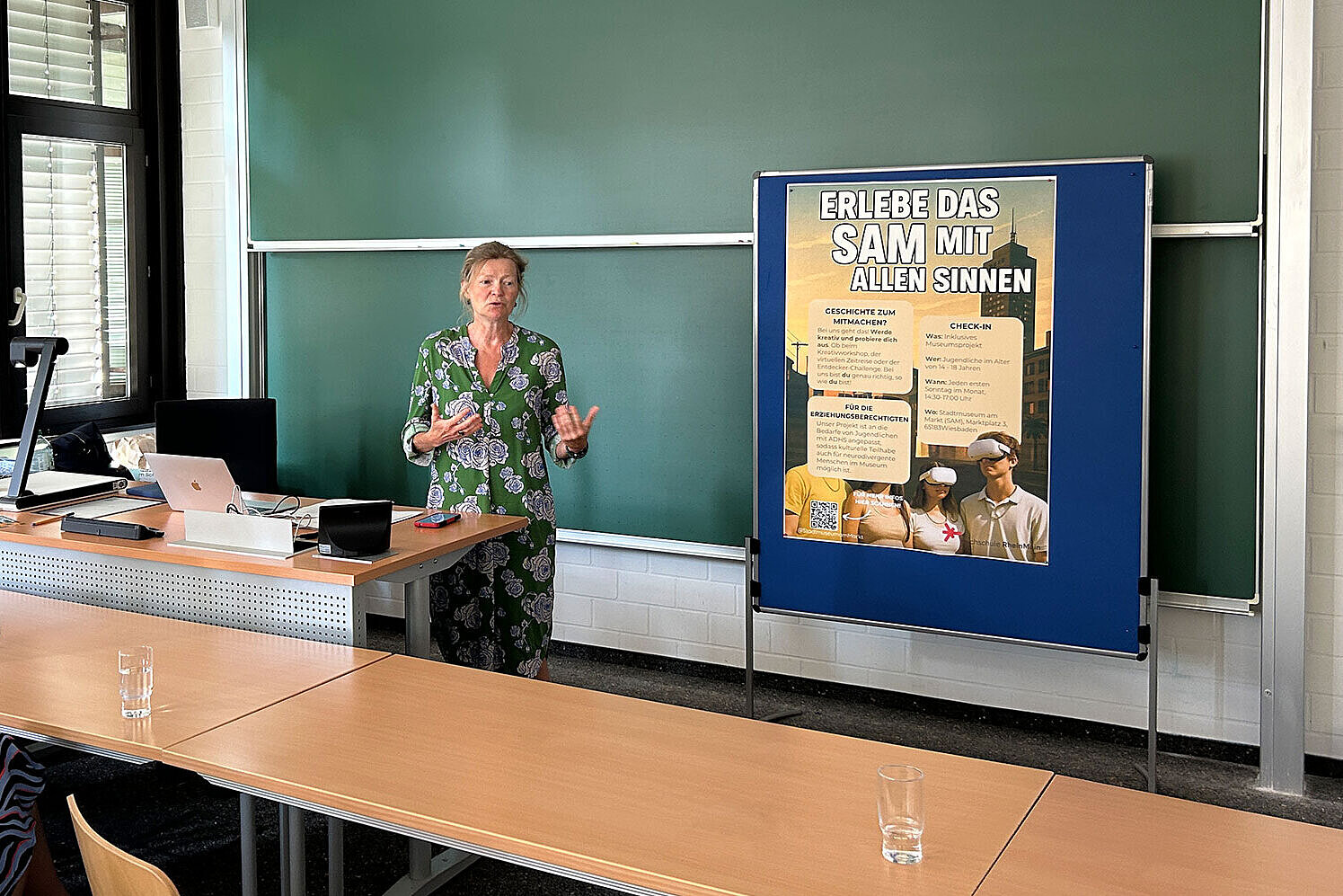 Sabine Philipp, Direktorin des Stadtmuseums am Markt, steht in einem Seminarraum der Hochschule RheinMain und hält ein Grußwort.