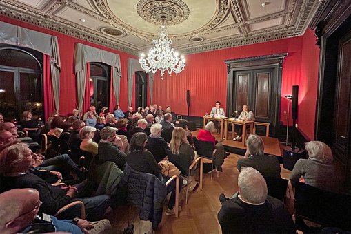 Blick in den gut gefüllten Veranstaltungsraum des Literaturhauses Villa Clementine. Auf der Bühne sitzen die Autorin Raphaela Edelbauer und Moderator Björn Hayer.