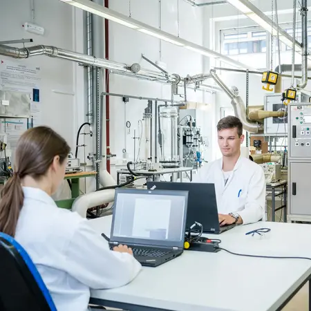 Bildaufnahme vom Verfahrenstechniklabor mit drei forschenden Personen 