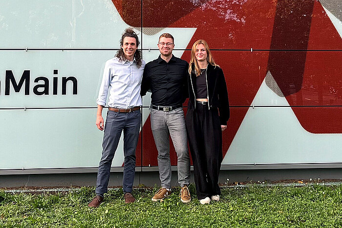 Das Gründungsteam der namowo GmbH steht vor einem Gebäude der Hochschule RheinMain.