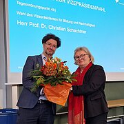 Prof. Dr. Eva Waller überreicht Prof. Dr. Christian Schachtner einen Blumenstrauß