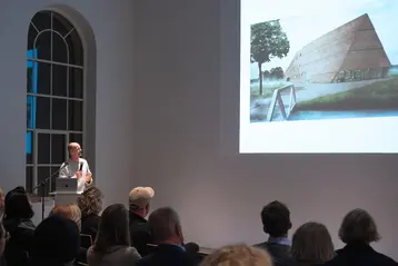 Prof. Thomas Kröger steht vor Publikum und hält einen Vortrag.