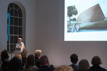 Prof. Thomas Kröger stands in front of an audience and gives a lecture.