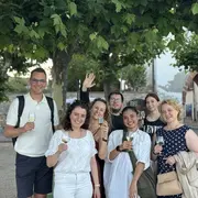 Die Teilnehmenden im Rheingau lächeln mit einem Glas Wein in die Kamera. 