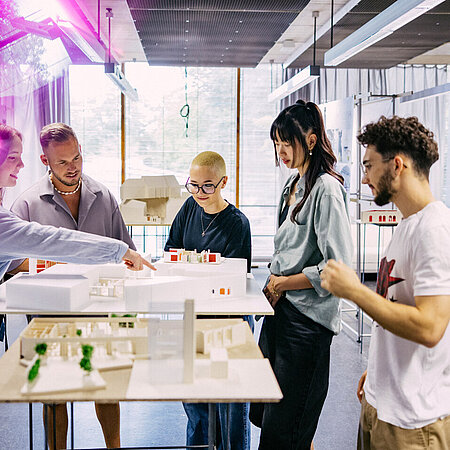 Studierende betrachten sich Modelle von Architekturprojekten