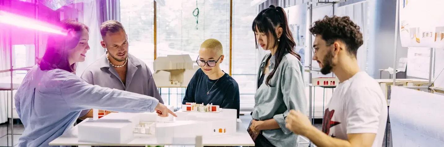 Studierende betrachten sich Modelle von Architekturprojekten