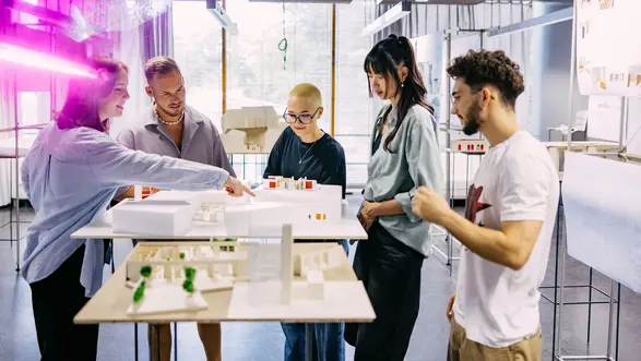 Studierende betrachten sich Modelle von Architekturprojekten