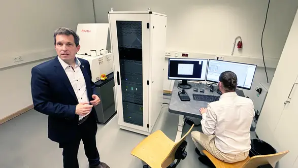 Prof. Dr. Bender (li.) und Doktorand Christopher Frick vor der e-Line-Elektronenstrahl-Lithografie-Anlage