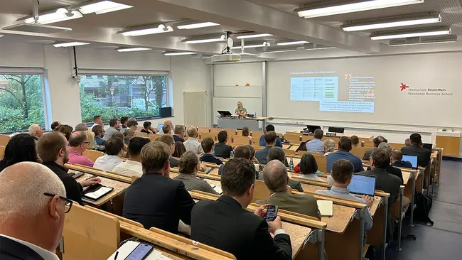 Judith Storm steht vor einem vollen Hörsaal