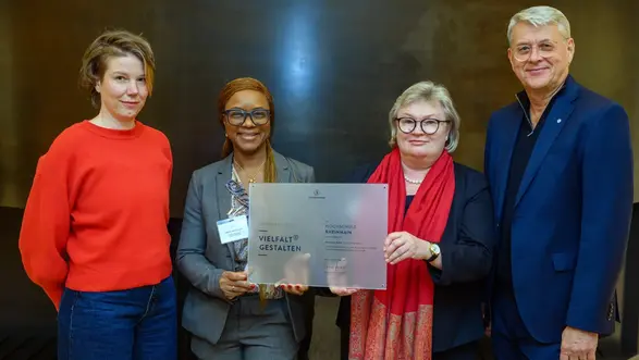 Kathrin Peltz, Prof. Dr. Abiola Sarnecki, Prof. Dr. Eva Waller und Dr. Volker Meyer-Guckel halten eine Plakette in die Kamera