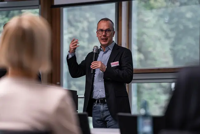Prof. Dr. Peter Winzer hält ein Mirkofron in der Hand und moderiert die Veranstaltung.
