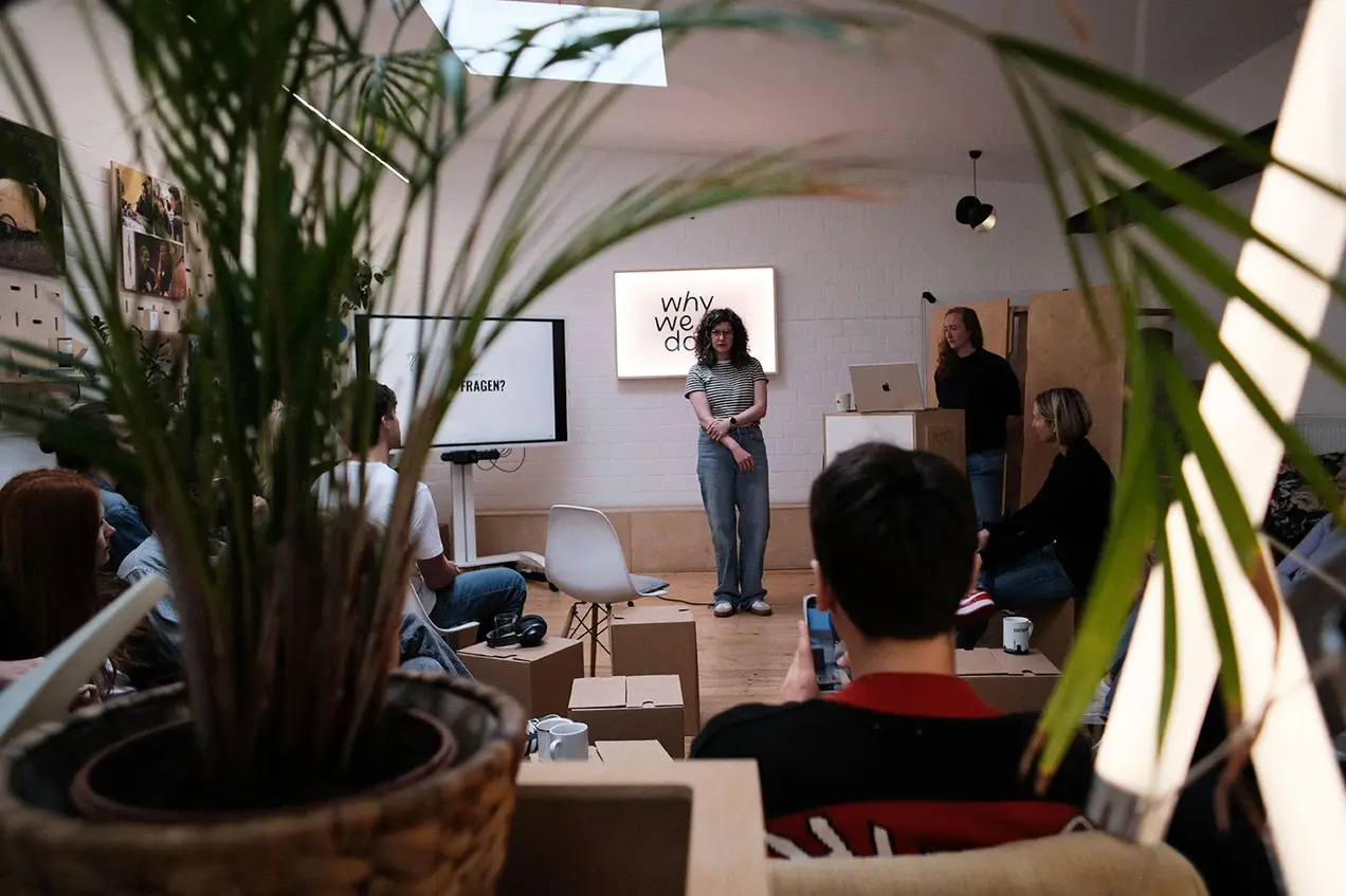 Eine Mitarbeiterin des Unternehmens Why we do hält eine Präsentation.