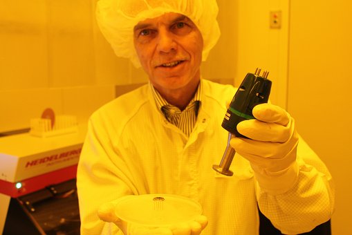 Prof. Dr. Friedemann Völklein mit einem Mikrosensor, der ein vielfaches mehr messen kann als das Gerät in seiner linken Hand.