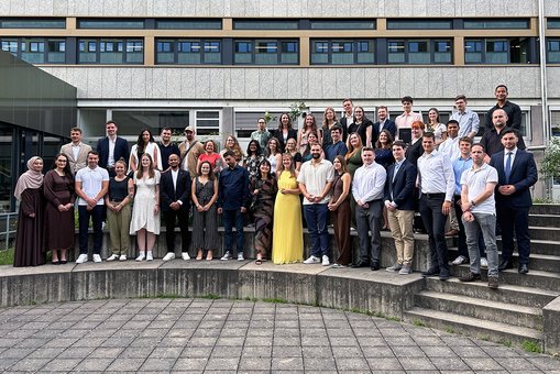 Absolvent:innen der Hochschule RheinMain posieren für ein Gruppenfoto.