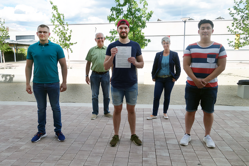 Kevin Weilbacher (WHS-Absolvent und zukünftiger Student der HSRM), Geert Ernst im Hintergrund (Abteilungsleiter WHS), Benjamin Rapp hält die Kooperationsvereinbarung in der Hand (auch WHS-Absolvent und zukünftiger Student der HSRM), Sonja Schmithals (Schulleiterin), Andreas Nguyen (HSRM-Student Interdisziplinäre Ingenieurwissenschaften). © Hochschulkommunikation | Hochschule RheinMain