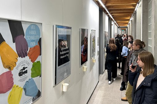 Besucher der Ausstellung betrachten die Plakate