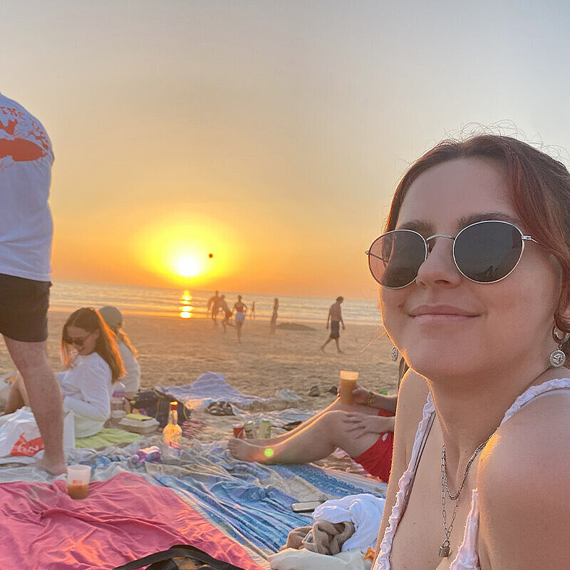 Sarah Faust Sarah Faust sitzt auf einer Decke am Strand