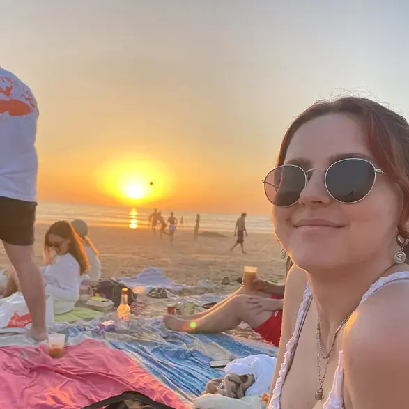 Sarah Faust Sarah Faust sitzt auf einer Decke am Strand