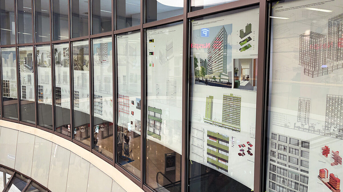 Eine Fensterwand mit Plakaten der Ausstellung