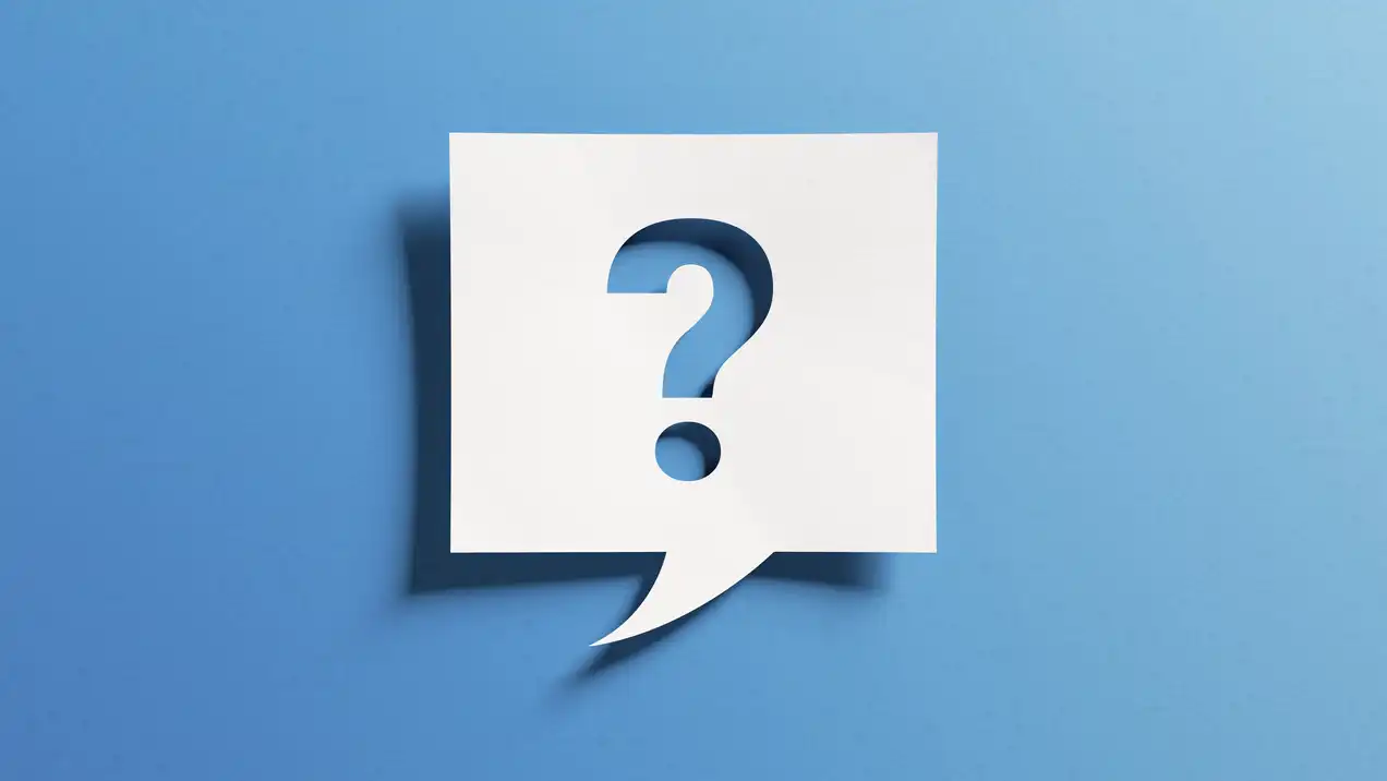 Ein weißes Sprechblasen-Symbol mit einem Fragezeichen in der Mitte, auf einem einfarbigen blauen Hintergrund. Die Darstellung vermittelt eine Frage oder Unsicherheit.