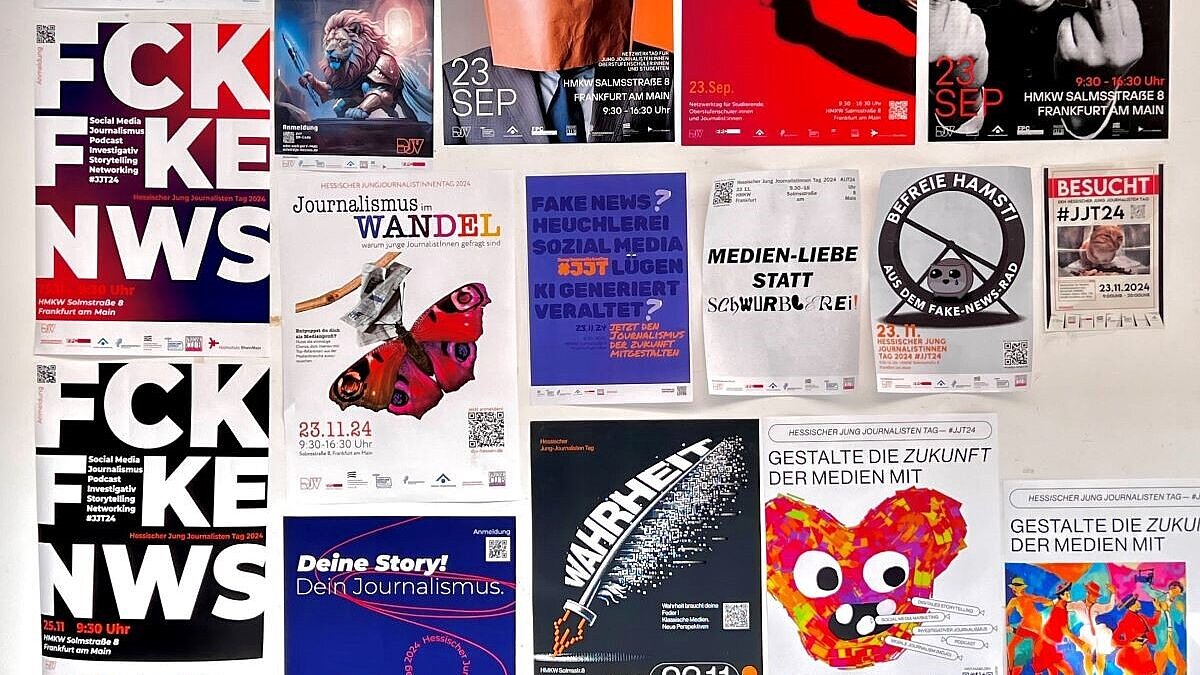 An einer Wand hängen eine Vielzahl von Plakaten