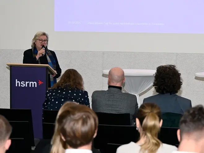 Präsidentin Prof. Dr. Eva Waller steht an einem Rednerpult der Hochschule RheinMain und spricht das Grußwort beim 2. Wiesbadener Tag für sozial nachhaltiges Investieren.