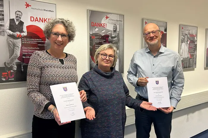 HSRM-Präsidentin Prof. Dr. Eva Waller steht zwischen Ruth Bieringer und Rainer Kreiselmaier, die jeweils ihre Ernennungsurkunde in den Händen halten.