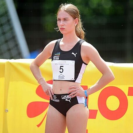 Porträt von Lara Tornow, Sprint Lara Tornow steht mit den Händen in der Hüfte auf dem Sportplatz