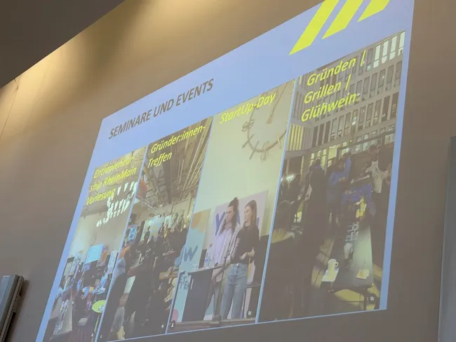 Das Bild zeigt eine Folie mit dem Titel "SEMINARE UND EVENTS". Es sind drei Fotos abgebildet: ein Gründerinnen-Treffen, der StartUp-Day und ein Netzwerkevent mit Glühwein und Networking. Die Atmosphäre wirkt lebhaft und einladend.