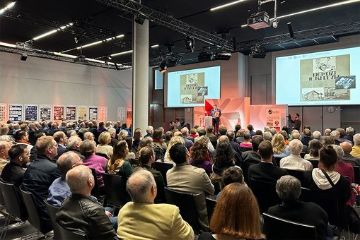 Blick den vollbesetzten Veranstaltungsraum, auf der Bühne steht Prof. Dr. Dr. Alexander Moutchnik